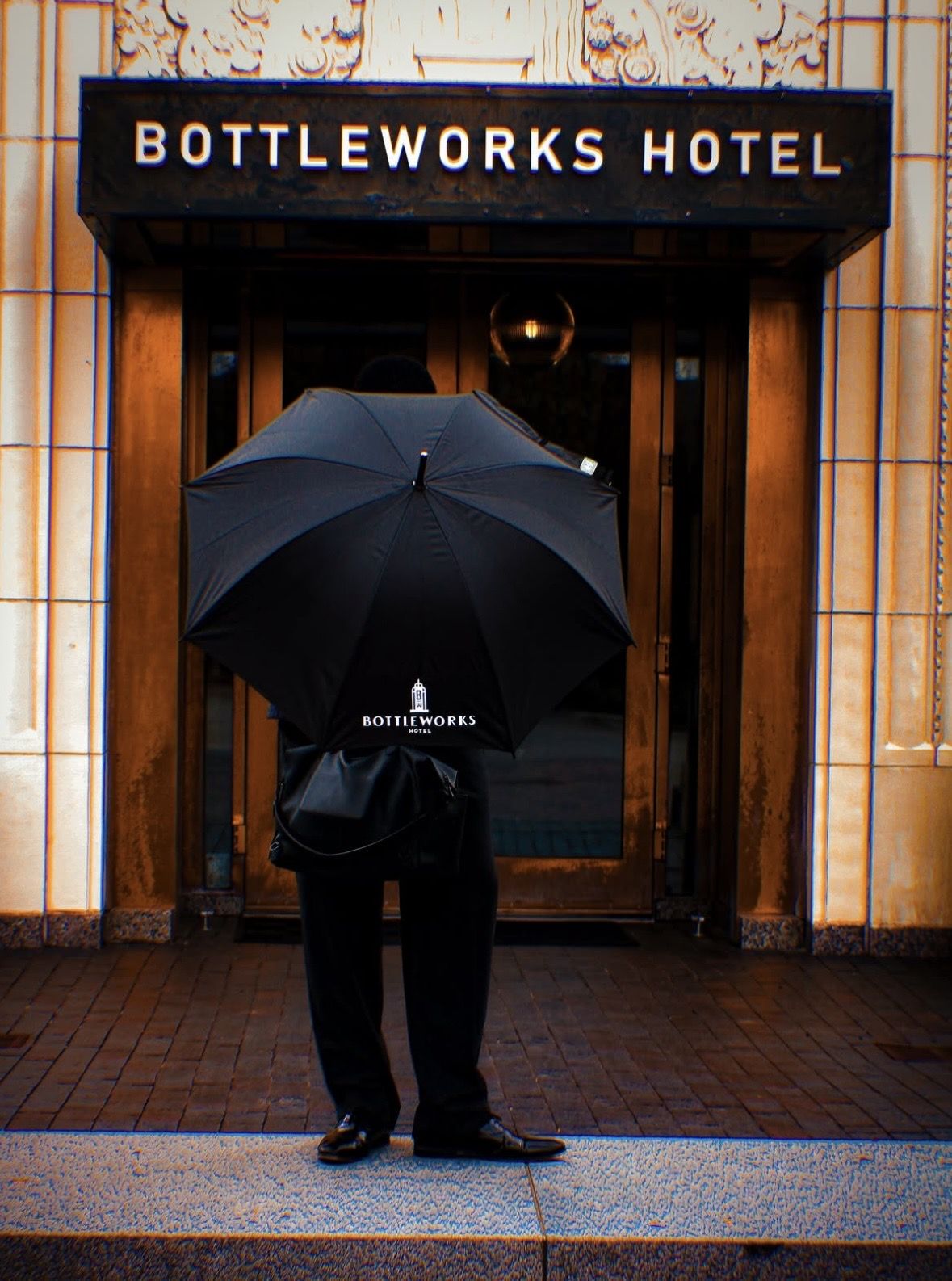 Guest with a Bottleworks umbrella at the hotel's entrance in Indianapolis