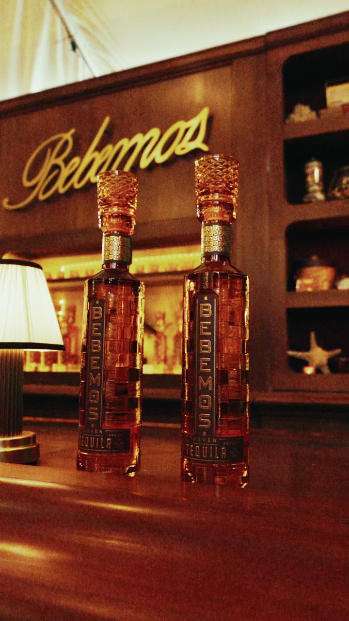 Two Bebemos tequila bottles on the bar under the Bebemos sign